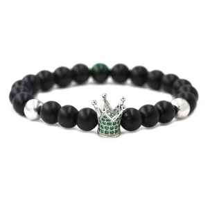 Detail of 8mm matte black beads bracelet featuring a silver crown with green zircons