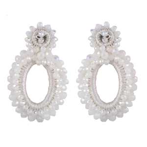 Macro view of handmade white iridescent seed bead bohemian oval dangle earrings