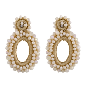 Detailed view of bohemian style earrings crafted with beige beads and gold thread work