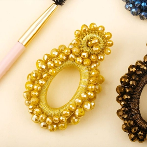 Detailed macro view of handmade yellow beaded earrings with intricate weaving technique