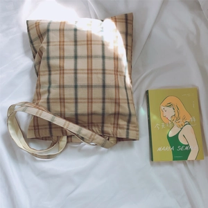 Detailed close-up of retro plaid cotton tote bag with vintage check pattern on white fabric
