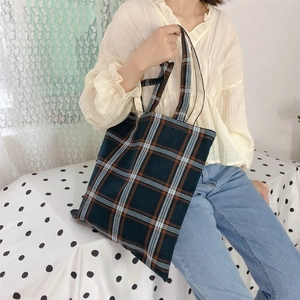 Detail view of large check canvas tote bag with brown and blue plaid pattern