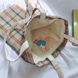 Detail of checkered canvas tote bag showing interior lining and open inner pocket