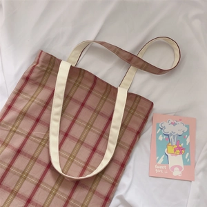 Detail of pink and brown plaid canvas tote bag with sturdy off-white cotton straps