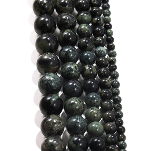 Detailed view of dark green eye stone beads in various sizes for DIY jewelry making