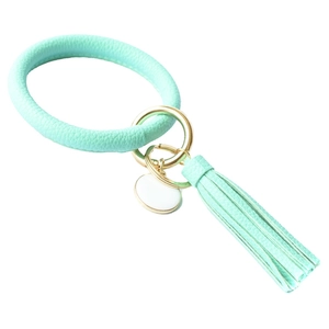 Detail view of mint green PU leather wristlet keychain with gold clasp and tassel