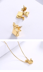 Detail of cute golden cat-shaped earrings and necklace set with a polished metal finish