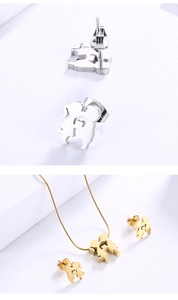 Detailed view of silver and gold stainless steel kissing children necklace and earring set