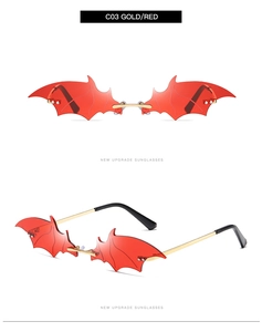 Detail view of red bat-shaped rimless sunglasses with gold metal temples and sharp cutout edges