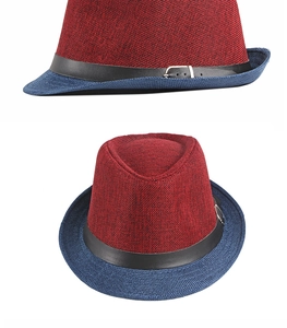Detail of red and navy knitted fedora hat featuring a black leather band with silver buckle