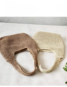Detail of woven straw shoulder bags in brown and beige with soft inner lining