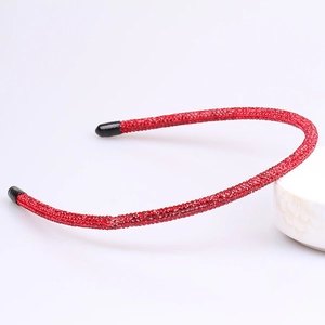 Detail of slim red headband fully encrusted with rhinestones and black non-slip ends