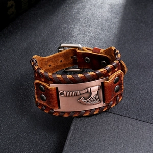 Close-up of brown leather Viking axe bracelet with embossed bronze metal plate and buckle