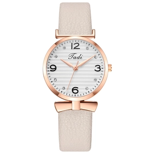 Détail du boîtier en or rose avec cadran blanc texturé et bracelet en cuir rose