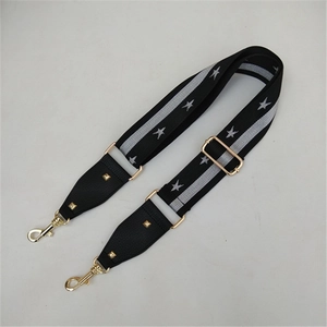 Detail of adjustable black strap with silver stars and gold metal swivel hooks for bags