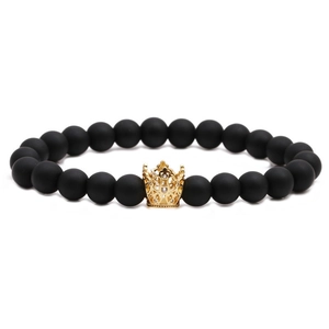 Matte black beaded crown bracelet with gold accents and rhinestones on white background