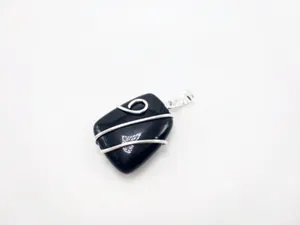 Detail of a wire-wrapped square black gemstone pendant with handcrafted silver winding