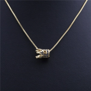 Elegante goldene Kronenhalskette mit blauen Zirkonia auf schwarzem Lederhintergrund