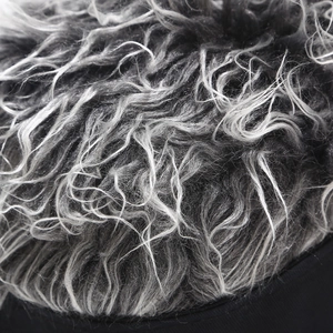 Macro detail of silver-grey curly synthetic wig hair attached to a black baseball cap base