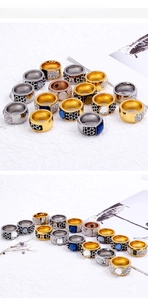 Detailed view of chunky alloy rings with pavé diamonds and blue crystals in gold finish