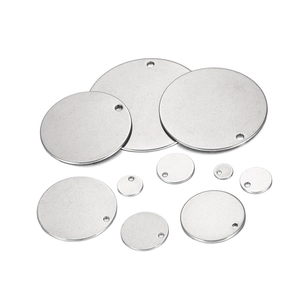 Macro view of various sizes of polished stainless steel round pendants with pre-drilled holes