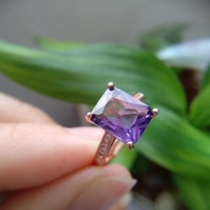 Macro view of rose gold ring with square amethyst stone and diamond accents