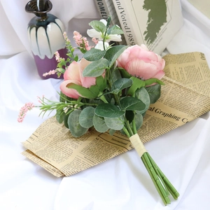 Pink silk peony bouquet with eucalyptus leaves on vintage newspaper for wedding decor