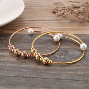 Vue détaillée des bracelets câbles en acier avec perles blanches et boules de cristal