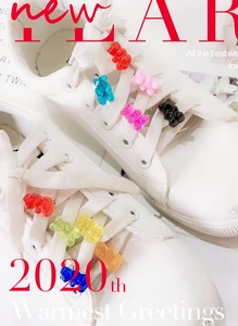 Close-up of colorful resin gummy bear charms attached to white sneaker shoelaces