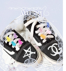 Detail shot of colorful gummy bear charms and logo patterns on black canvas shoes