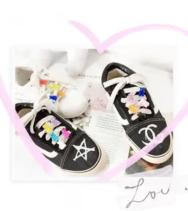 Macro detail of gummy bear charms on low-top canvas shoes with star patterns