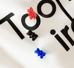 Macro shot of colorful resin gummy bear pins in red, black, and blue colors