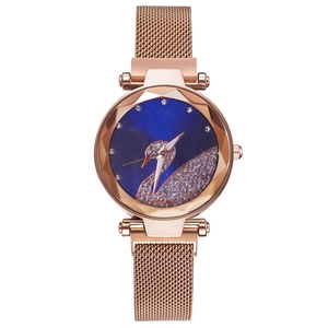 Detail of rose gold mesh band watch with a blue dial and rhinestone swan design