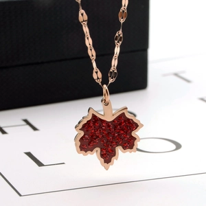 Ahornblatt-Halskette in Roségold mit roten Kristallen auf einer passenden Kette vor Box