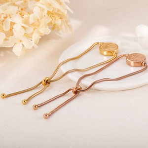 Detail of adjustable stainless steel disc bracelets in gold and rose gold finishes