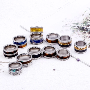 Assorted stainless steel rings with shell inlays and Roman numerals on stylish background