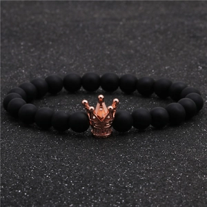Détail de perles noires mates et charm couronne en or rose orné de zircons cubiques