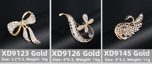 Détails de broches dorées avec strass scintillants en forme de nœud et de cygne élégant