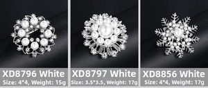 Détails de trois broches élégantes avec perles et strass sur un fond noir contrasté