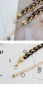 Detail of elegant black and gold woven waist chain belt with metallic buckle and links