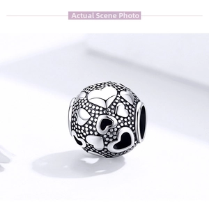 Macro shot of S925 sterling silver heart charm with vintage oxidized texture and details