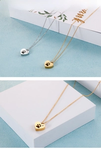 Detailed view of silver and gold heart necklaces featuring delicate pet paw cutouts
