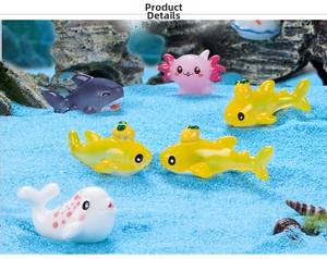 Miniature ocean animal figurines including axolotl and sharks on blue sand seabed