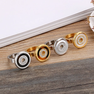 Rose gold and silver shell rings with crystals arranged on a wooden background