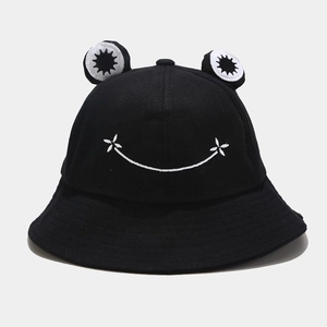 Detail of cute black bucket hat featuring 3D frog eyes and white embroidered smile