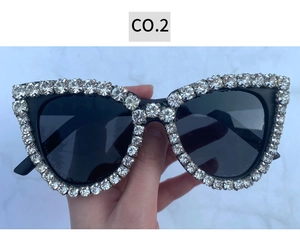 Close-up of cat-eye sunglasses with large sparkling rhinestones and black lenses