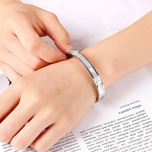 Minimalist silver titanium steel bracelet with 8mm shell inlay worn by a female model