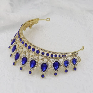 Detailed macro of gold bridal tiara featuring blue teardrop gems and clear rhinestones