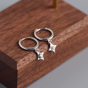 Macro detail of S925 sterling silver star hoop earrings with sparkling zircon inlay