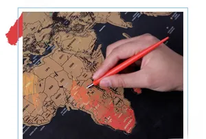 Close-up of red plastic scratch tool with metal tip used on a black scratch-off world map